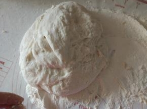 案板上放适量的面粉，面团排气