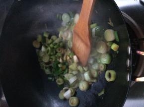 锅内加入适量油，把葱放入锅中翻炒一分钟左右