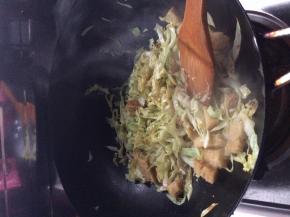 锅内放入适量油，把卷心菜放入锅中翻炒一分钟左右，随后放入面筋和凉皮