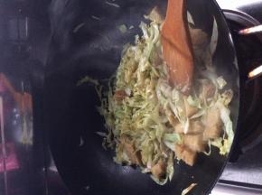 锅内放入适量油，把卷心菜放入锅中翻炒一分钟左右，随后放入面筋和凉皮