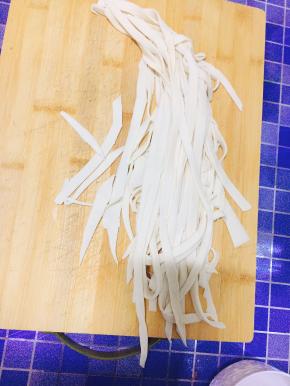 4. 将面团用擀面杖擀开，并用刀切成条状。