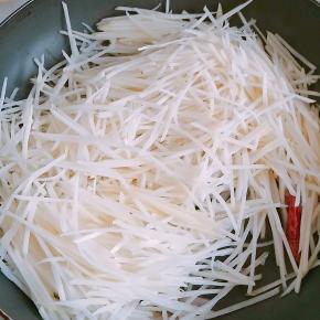 6.放入土豆丝快速翻炒，以防粘锅。