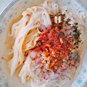 5.煮好后捞出，表面放上准配好的配料，洋葱末、姜蒜末、花椒粉、盐、鸡精、辣椒面、少许醋、酱油、芝麻。