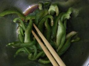 把青椒和黄瓜放入盆中，加入香油，盐等调料，搅拌均匀