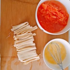 2．西红柿去皮切碎，鸡蛋加水打散，豆皮切丝。