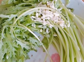 2．茼蒿洗好放入盘中，蒜切末放入茼蒿之上。