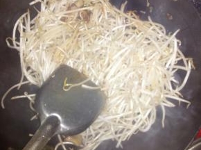 把豆芽放锅里炒。同时下辅料，爆炒十多分钟。