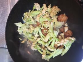 加入有机花菜，和肉、辅料一起煸炒。