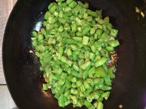 将豆角放进锅中，加入盐、酱油、糖煸炒。