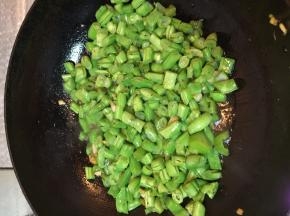 将豆角放进锅中，加入盐、酱油、糖煸炒。