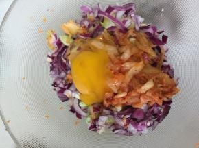 将上述佐料放在一起，加入少许泡菜、泡菜汁，再打入一个鸡蛋活匀。