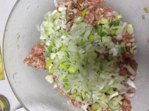 大葱放入肉馅，加点水，顺着一个方向拌匀。