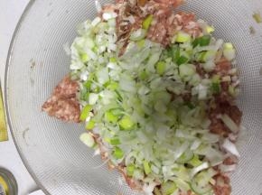 大葱放入肉馅，加点水，顺着一个方向拌匀。