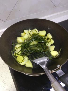 锅内放少许的油，加入土豆进行翻炒，放入海带，加入热水