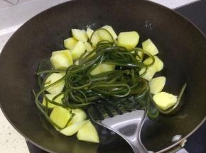 锅内放少许的油，加入土豆进行翻炒，放入海带，加入热水