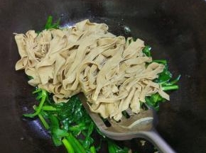 锅内放入适量的油，烧热放入韭菜豆皮，加入调味料翻炒