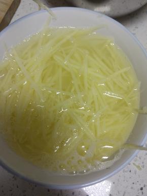 土豆去皮，擦细丝泡凉水