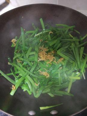 锅内放少许的油加入韭菜翻炒，放入清洗干净的虾皮