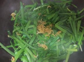 锅内放少许的油加入韭菜翻炒，放入清洗干净的虾皮