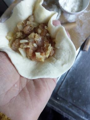 然后把皮擀好，把馅装到皮上，包成小包子。