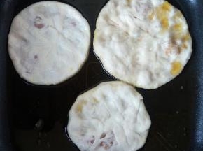 把小包子放在水中，然后双手对贴成饼，烙在锅里。