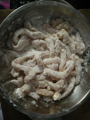 3.将裹好蛋液的鸡柳条放入淀粉盘中，均匀的裹好淀粉