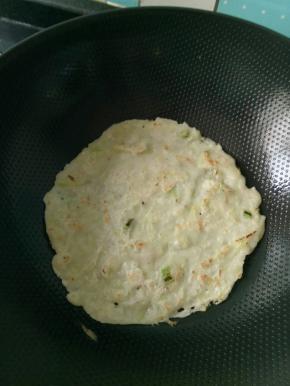 3.锅里倒少量的油，油热倒入一勺面糊，用铲子摊平