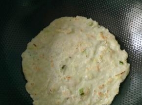3.锅里倒少量的油，油热倒入一勺面糊，用铲子摊平