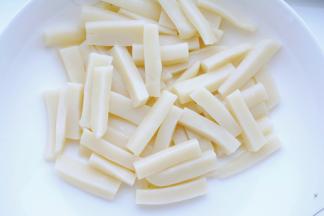 年糕用水清洗备用。
（洗过之后就不粘到一起了，便于翻炒。）