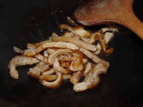 当冰糖全部融化时，要立即（冰糖熬久会苦）将猪肚倒入中大火翻炒上色。