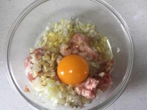把葱姜切碎,打入一个鸡蛋和肉馅拌匀，打上劲