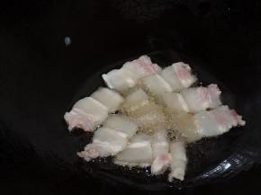 锅内热少许油，直到插入筷子有小气泡冒出现在筷子周围时，下入五花肉片小火慢煎。如果五花肉较多，分多次煎。煎至五花肉微微翘起，肥肉部分较为透明、瘦肉部分微焦时，翻面继续煎。两面煎好即可将五花肉盛起。