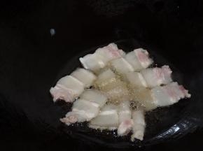 锅内热少许油，直到插入筷子有小气泡冒出现在筷子周围时，下入五花肉片小火慢煎。如果五花肉较多，分多次煎。煎至五花肉微微翘起，肥肉部分较为透明、瘦肉部分微焦时，翻面继续煎。两面煎好即可将五花肉盛起。