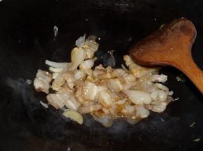 下入五花肉翻炒，使酸荞头味道进入肉中。放1/4汤勺花雕酒、2汤勺生抽，继续翻炒均匀。直至五花肉稍老时即可起锅。