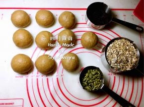 滚圆松弛10分钟，准备好表面装饰谷物，燕麦片、南瓜籽、葵花籽铺在烤盘上，送入烤箱烘烤一下，140度烤5分钟。黑芝麻140度烤三分钟。烤箱不用预热哦！
