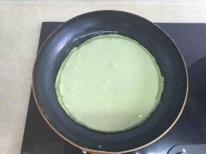 在平底锅中加入油，然后倒入面糊，摊开，待凝固。