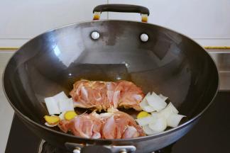 腿挑出去葱姜，
鸡皮朝下平铺到锅中，
把葱姜放到锅中，不要和鸡腿粘连~
调成中小火，慢慢煎制~