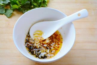 烧水汆烫豆皮等待的过程中准备拌菜的酱料~
容器中放入适量的辣椒粉，芝麻，十三香，以及蒜碎~
干料容易糊掉的放下面，蒜碎放到上面~