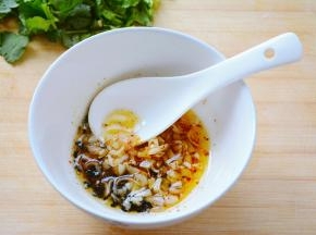 烧水汆烫豆皮等待的过程中准备拌菜的酱料~
容器中放入适量的辣椒粉，芝麻，十三香，以及蒜碎~
干料容易糊掉的放下面，蒜碎放到上面~