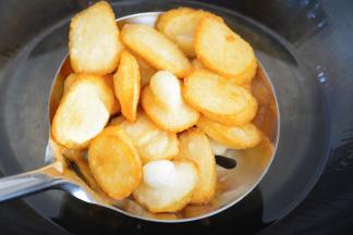 在锅子里要两面翻动一下，
让年糕受热均匀~
否者..就像其中的几个一样，会有一面突出~

中途觉得油温不够热，
用漏勺把年糕捞出~
升温后在复炸~
年糕炸好的口感应该是外脆内软的~
切记不要小火慢炸，
把年糕的水分耗尽，就会硬梆梆的~