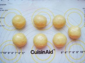 面团放在垫子上排气，平均分成7个小剂子揉成光滑的小圆球。