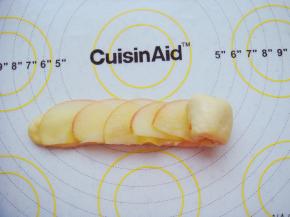 叠加摆放上苹果片从一端按紧卷起来。