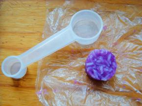 小量勺里铺上保鲜膜，填入米饭压实。拉出保鲜膜很轻松就刻出了小小的圆饭团，同样方法刻出原色饭团。