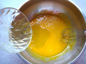 蛋黄里加入3克盐，加入15克的白砂糖，用手动搅拌器搅拌均匀后，加入玉米油。