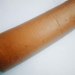  出炉后2分钟倒扣在烤网上，撕掉油纸。然后倒扣回来，表面虚盖油纸放凉。待微温状态借助擀面杖卷起来，放入冰箱30分钟定型