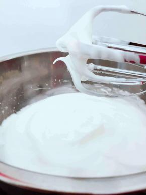  将20g细砂糖分次加入到蛋白中，打发到湿性发泡，如图，提起打蛋器蛋白呈弯钩状；