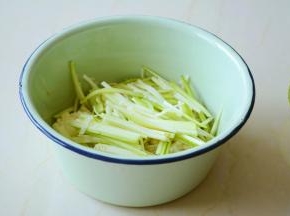 把过凉的金针菇攥净多余的水分与西葫芦丝放容器中。