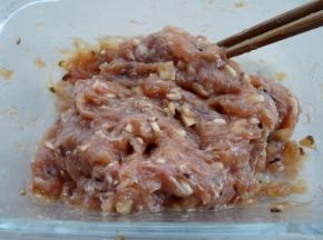 肉末加入1大勺酱油、1大勺蚝油、少许盐、少许糖，继续顺时针搅拌均匀。