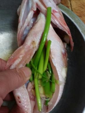 将葱段姜丝八角白胡椒盐填入肚里。