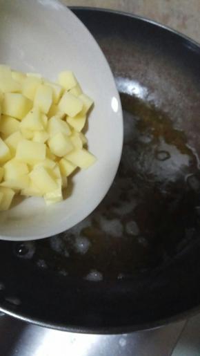 再将土豆丁倒入锅中炸制